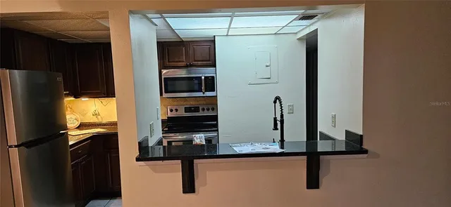 a view of a kitchen with refrigerator and workspace