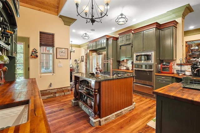 a large kitchen with stainless steel appliances granite countertop a stove and cabinets