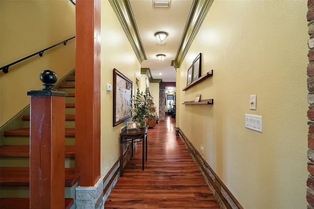 a view of a hallway with wooden floor and staircase
