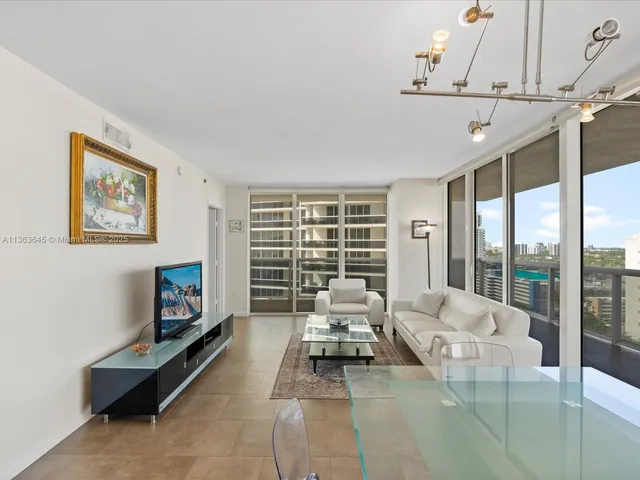 a living room with furniture a flat screen tv and a large window