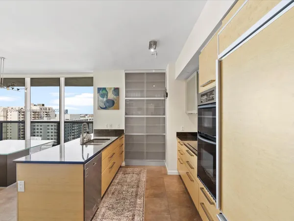 a kitchen with stainless steel appliances a stove and a large window