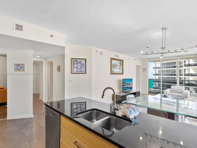 a kitchen with stainless steel appliances granite countertop a sink and a refrigerator