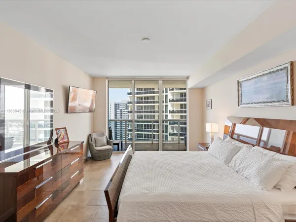 a bedroom with a bed a couch and a dresser next to a window