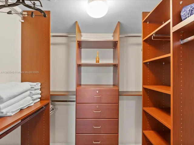 a view of walk in closet with clothes and shoes