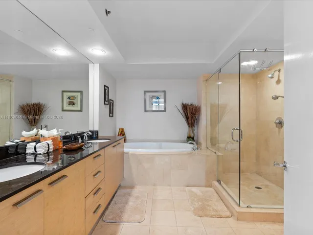 a spacious bathroom with a granite countertop tub sink and glass door
