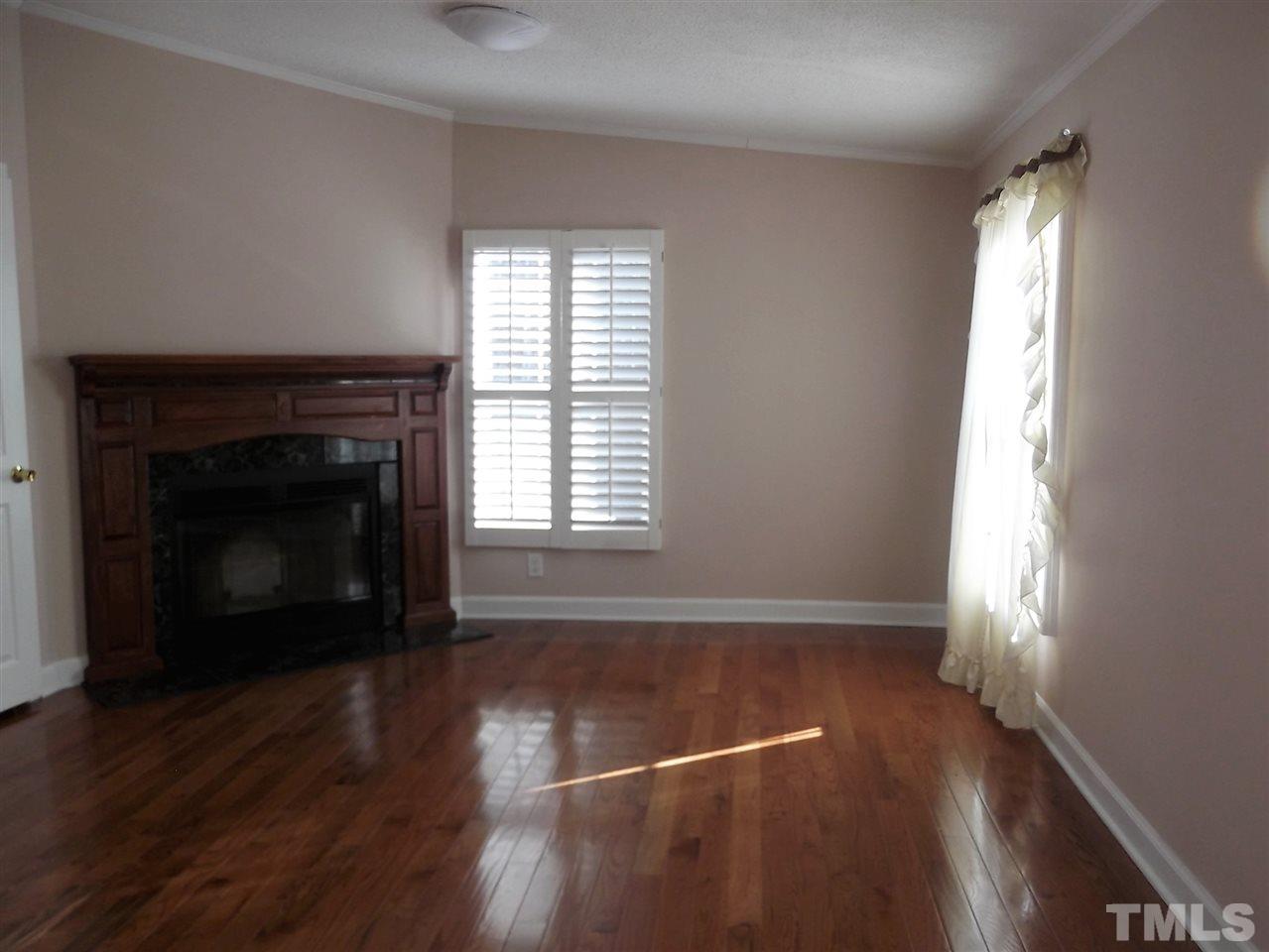 1060 Wrenn Crumpton Road Roxboro, NC 27574 - Photo 11 of 21 an empty room with wooden floor fireplace and windows
