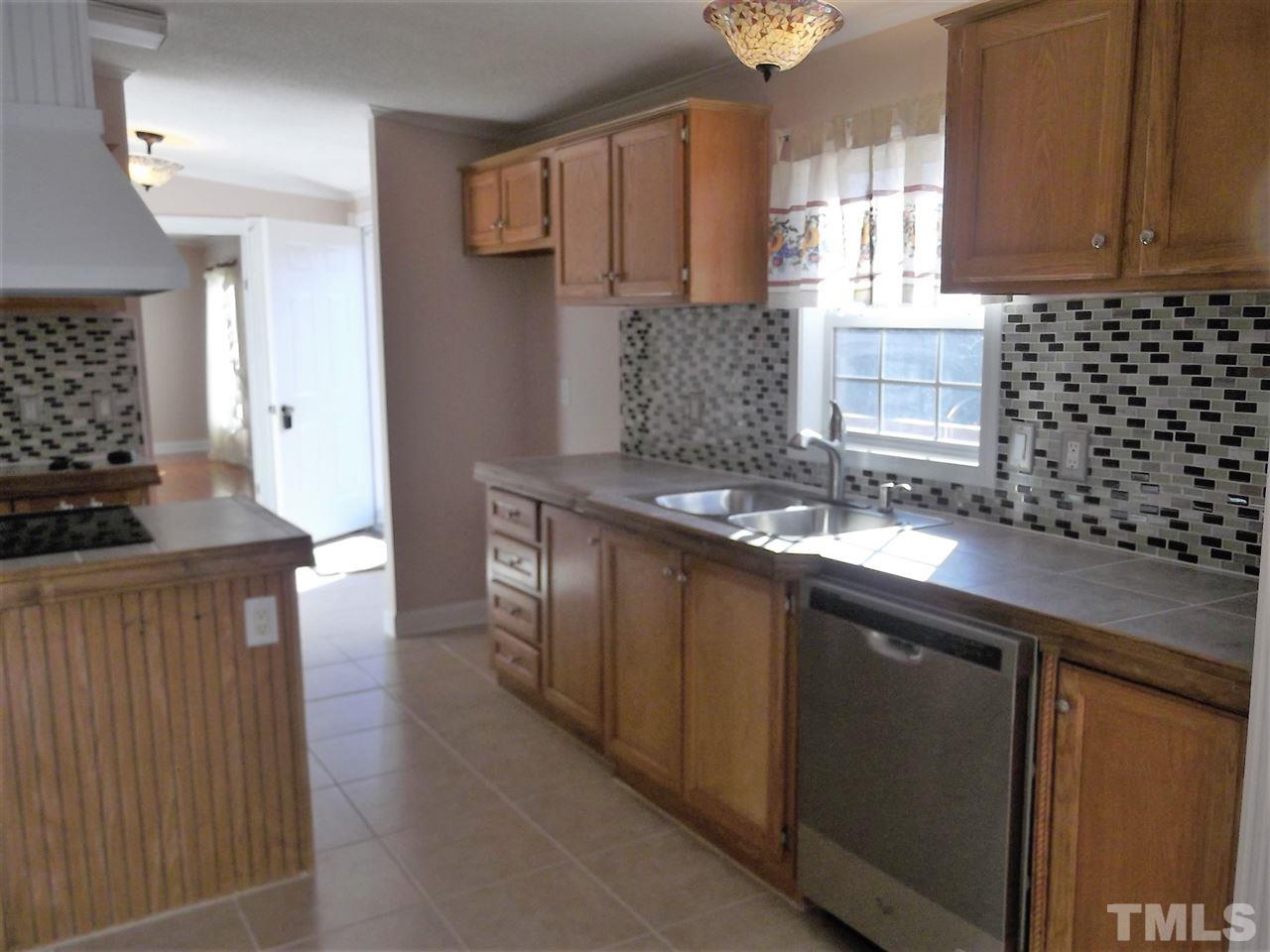 1060 Wrenn Crumpton Road Roxboro, NC 27574 - Photo 6 of 21 a kitchen with stainless steel appliances granite countertop a sink a stove and a refrigerator