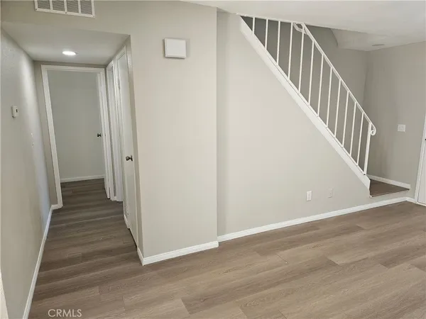 a view of a hallway with wooden floor and entryway