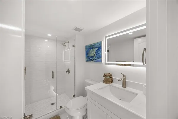 a bathroom with a sink a toilet and shower