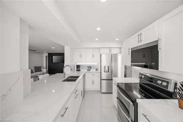 a large white kitchen with a stove a sink and a refrigerator