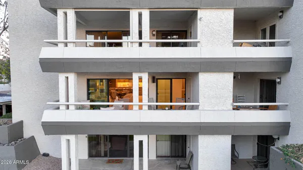a view of a building with patio furniture and a patio