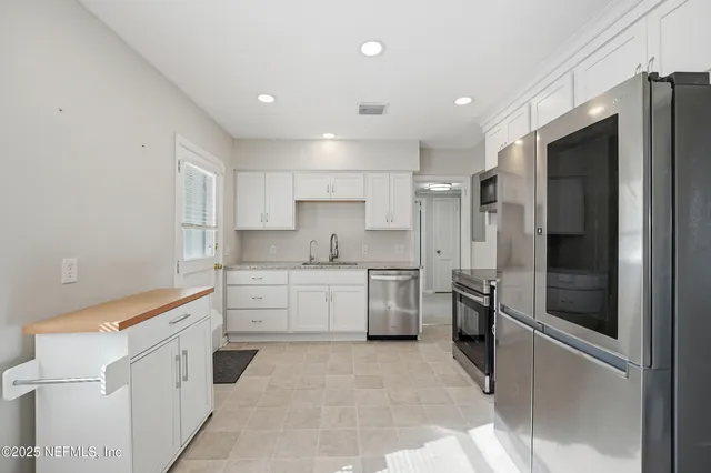 a kitchen with a refrigerator sink and cabinets