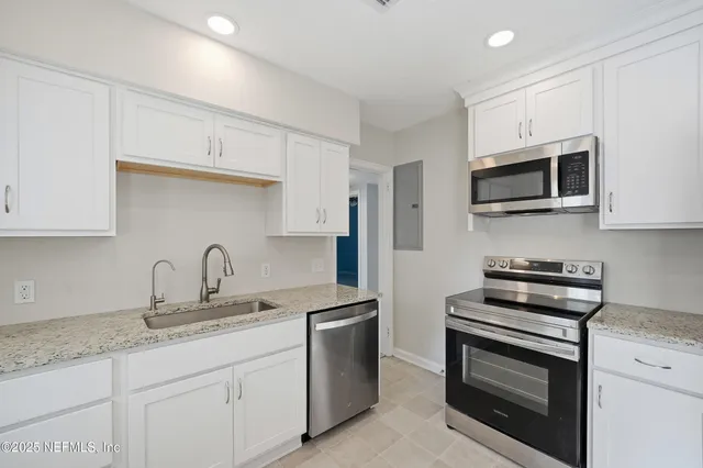 a kitchen with cabinets stainless steel appliances a sink and a microwave