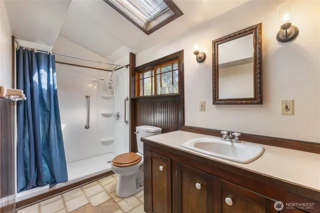 a bathroom with a sink a toilet and shower