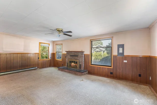 a view of an empty room with a fireplace and a window