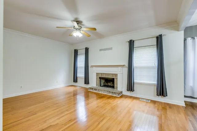 a view of an empty room with a fireplace and a window