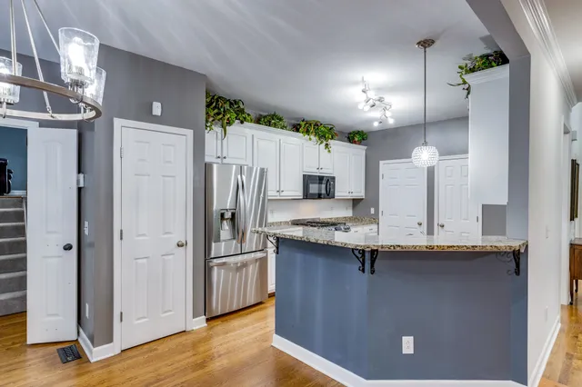 a kitchen with granite countertop a sink stove and refrigerator