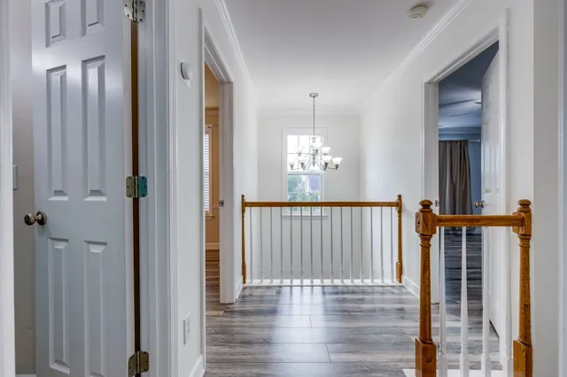 a room with wooden floors pool table and windows