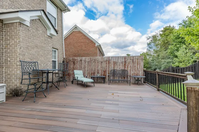 a view of backyard with seating space and wooden fence