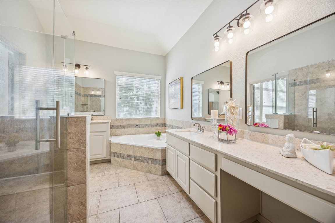 3329 Eagle Ridge Lane Pflugerville, TX 78660 - Photo 17 of 35 Full bath featuring two vanities, a bath, a stall shower, and light tile patterned floors