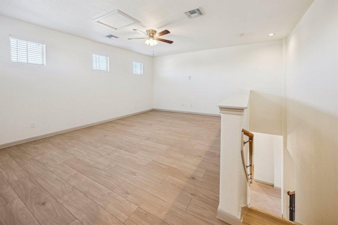 3329 Eagle Ridge Lane Pflugerville, TX 78660 - Photo 18 of 35 Empty room with light wood-type flooring, attic access, ceiling fan, and recessed lighting