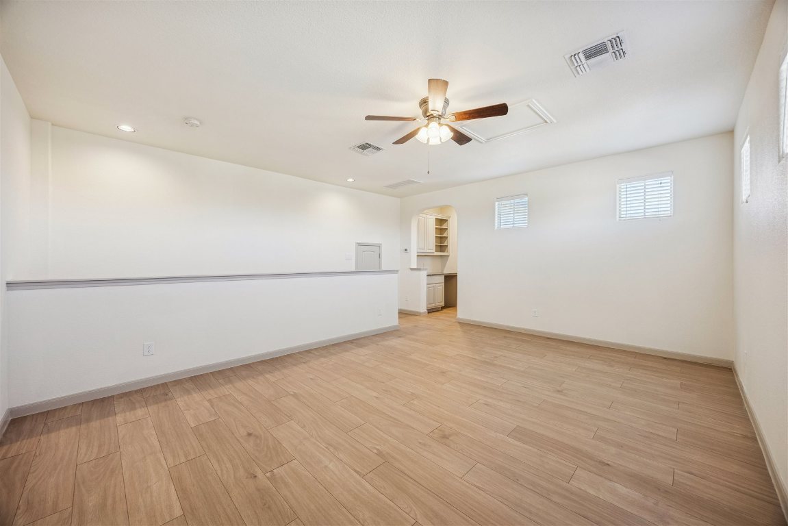 3329 Eagle Ridge Lane Pflugerville, TX 78660 - Photo 19 of 35 Unfurnished room featuring light wood-type flooring, ceiling fan, recessed lighting, arched walkways, and attic access