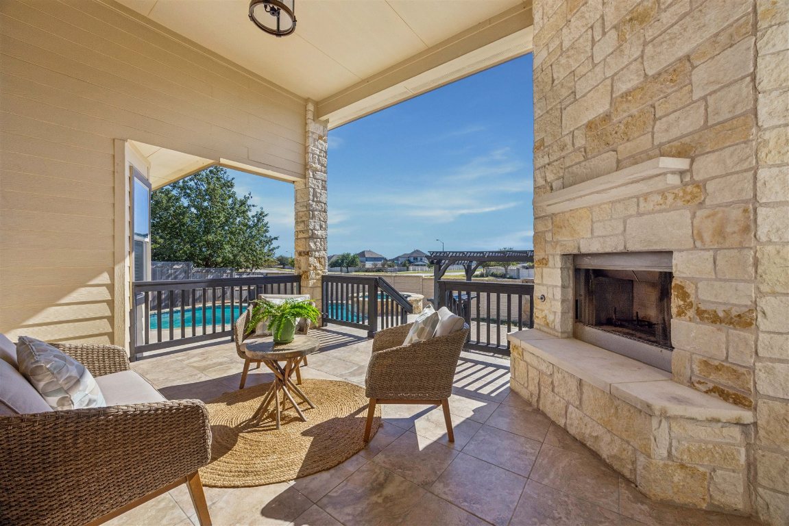 3329 Eagle Ridge Lane Pflugerville, TX 78660 - Photo 27 of 35 Balcony with an outdoor stone fireplace and view of pool area