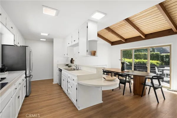 a large white kitchen with a large window and stainless steel appliances