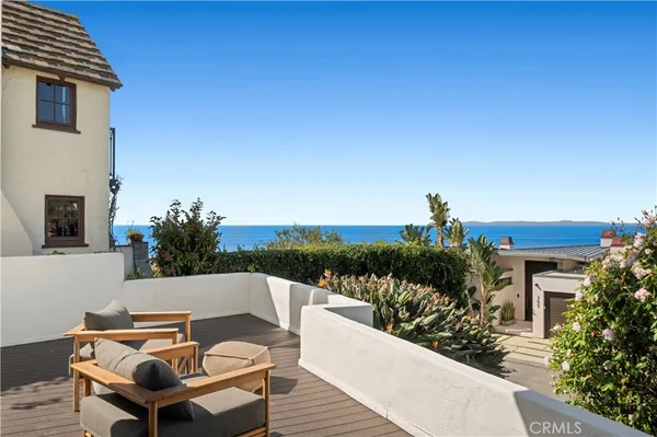 a roof deck with table and chairs potted plants with wooden floor