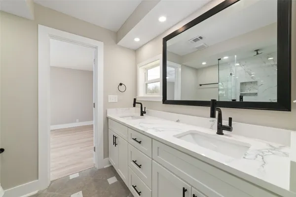 a spacious bathroom with a shower sink and mirror
