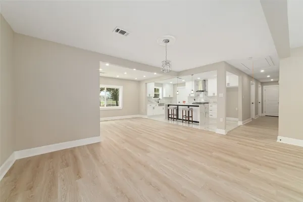a view of an empty room and kitchen view