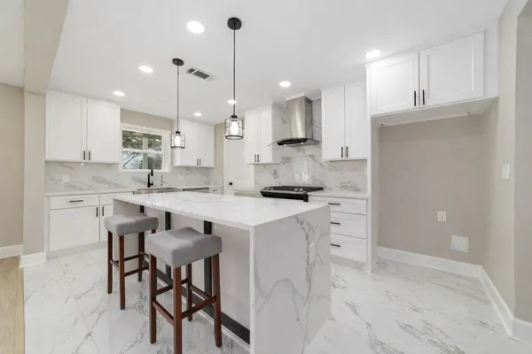 a kitchen with white cabinets and stainless steel appliances