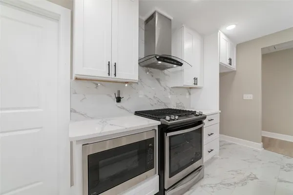 a kitchen with stainless steel appliances white cabinets and a stove
