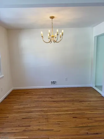 a view of wooden floor and a chandelier