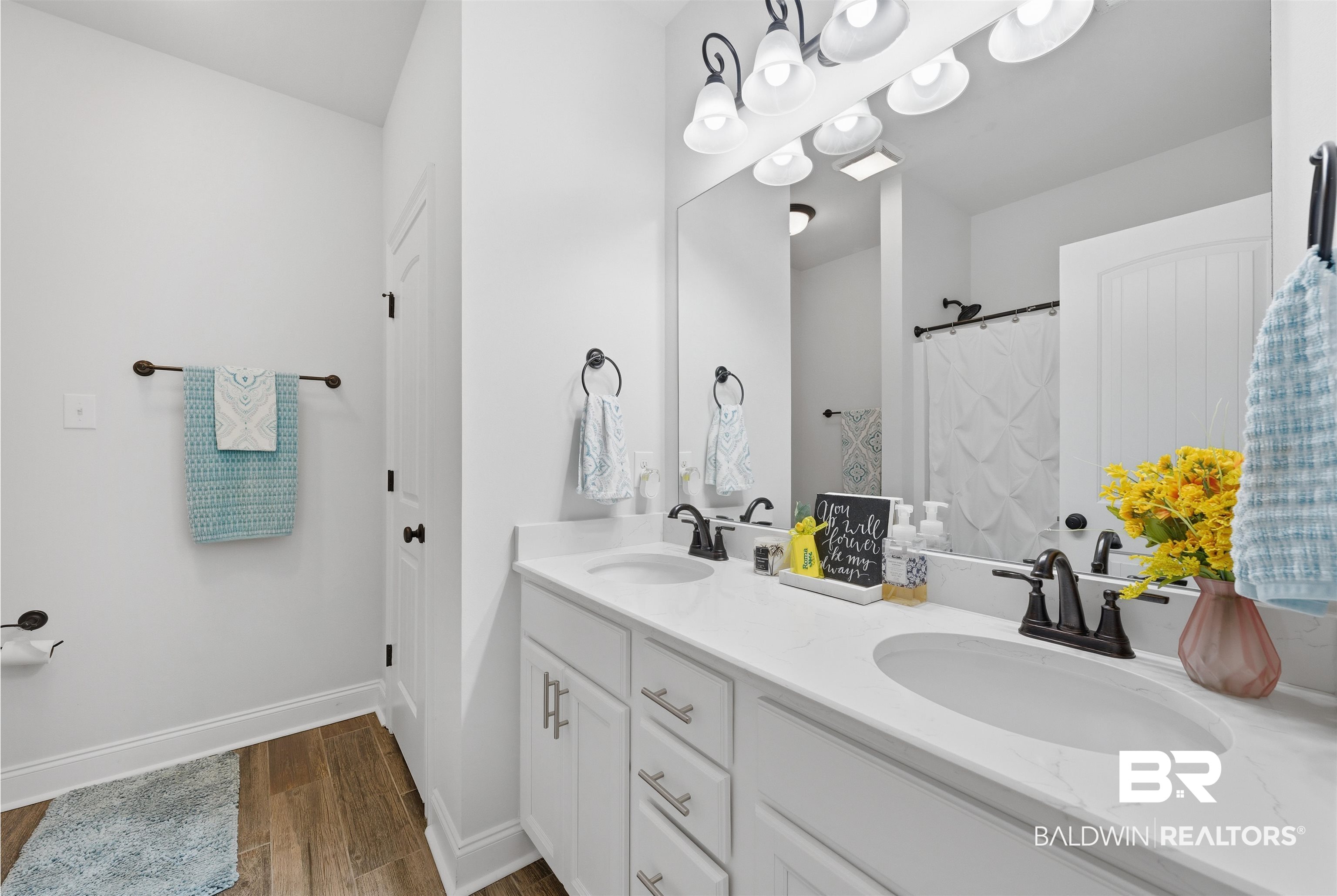 22512 Putter Lane Foley, AL 36535 - Photo 12 of 27 Bathroom with double vanity, curtained shower, and dark wood finished floors