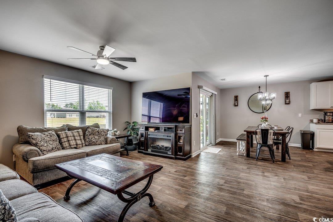 777 Woodland Farms Circle Aynor, SC 29511 - Photo 12 of 31 Living area with baseboards, ceiling fan with notable chandelier, dark wood-style flooring, and plenty of natural light