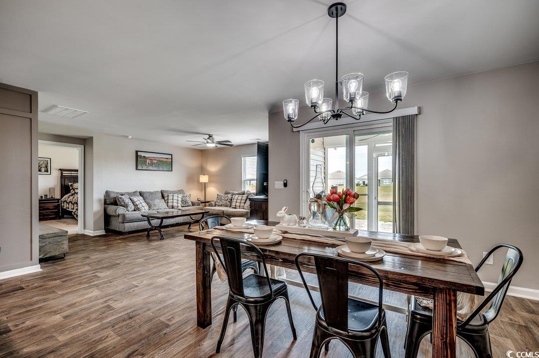 777 Woodland Farms Circle Aynor, SC 29511 - Photo 10 of 31 Dining area with baseboards, visible vents, wood finished floors, and ceiling fan with notable chandelier