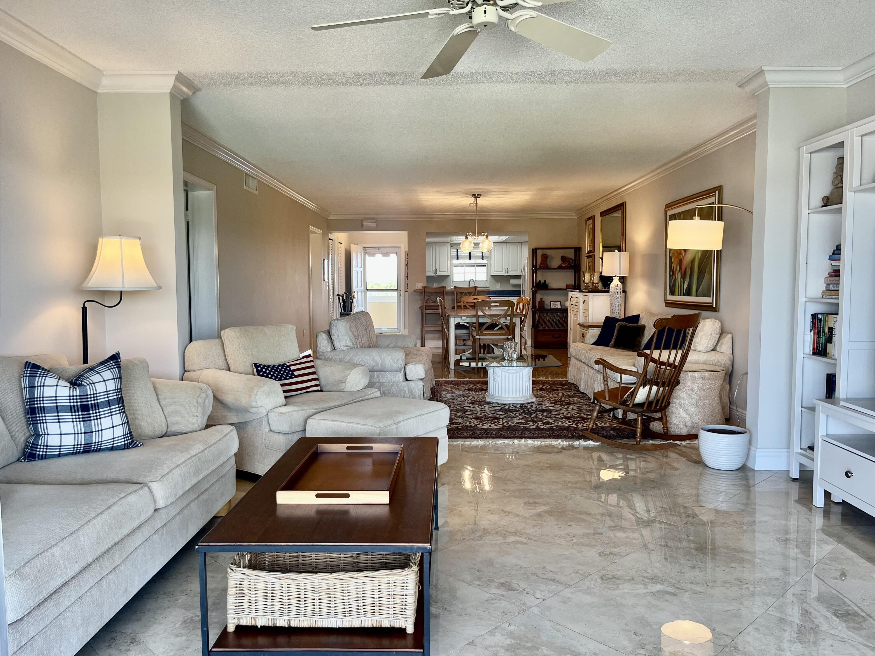145 Atlantis Boulevard, Unit PH4 Atlantis, FL 33462 - Photo 11 of 27 a living room with furniture and a lamp