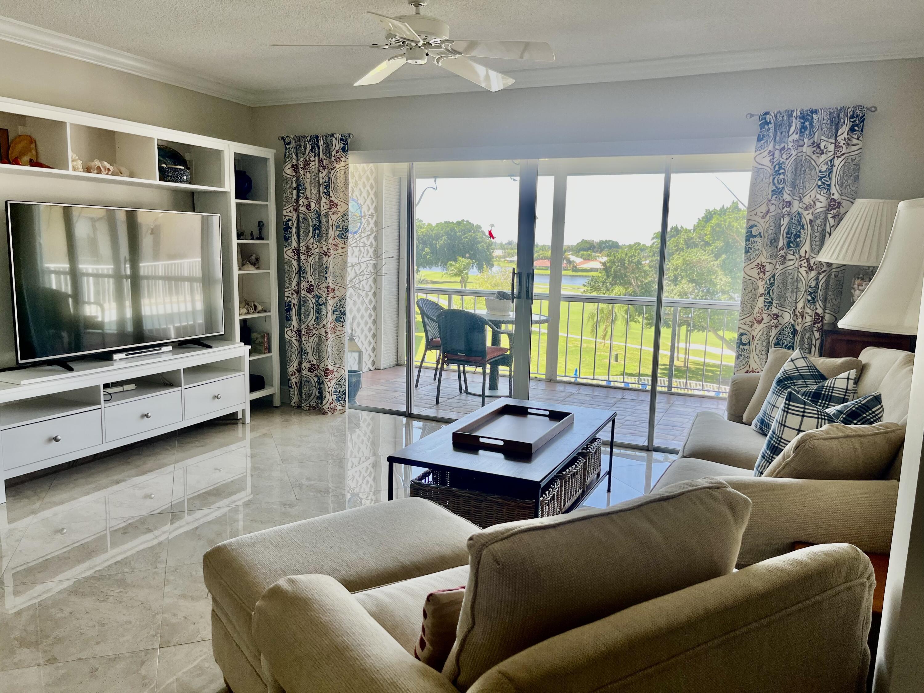 145 Atlantis Boulevard, Unit PH4 Atlantis, FL 33462 - Photo 6 of 27 a living room with furniture and a flat screen tv
