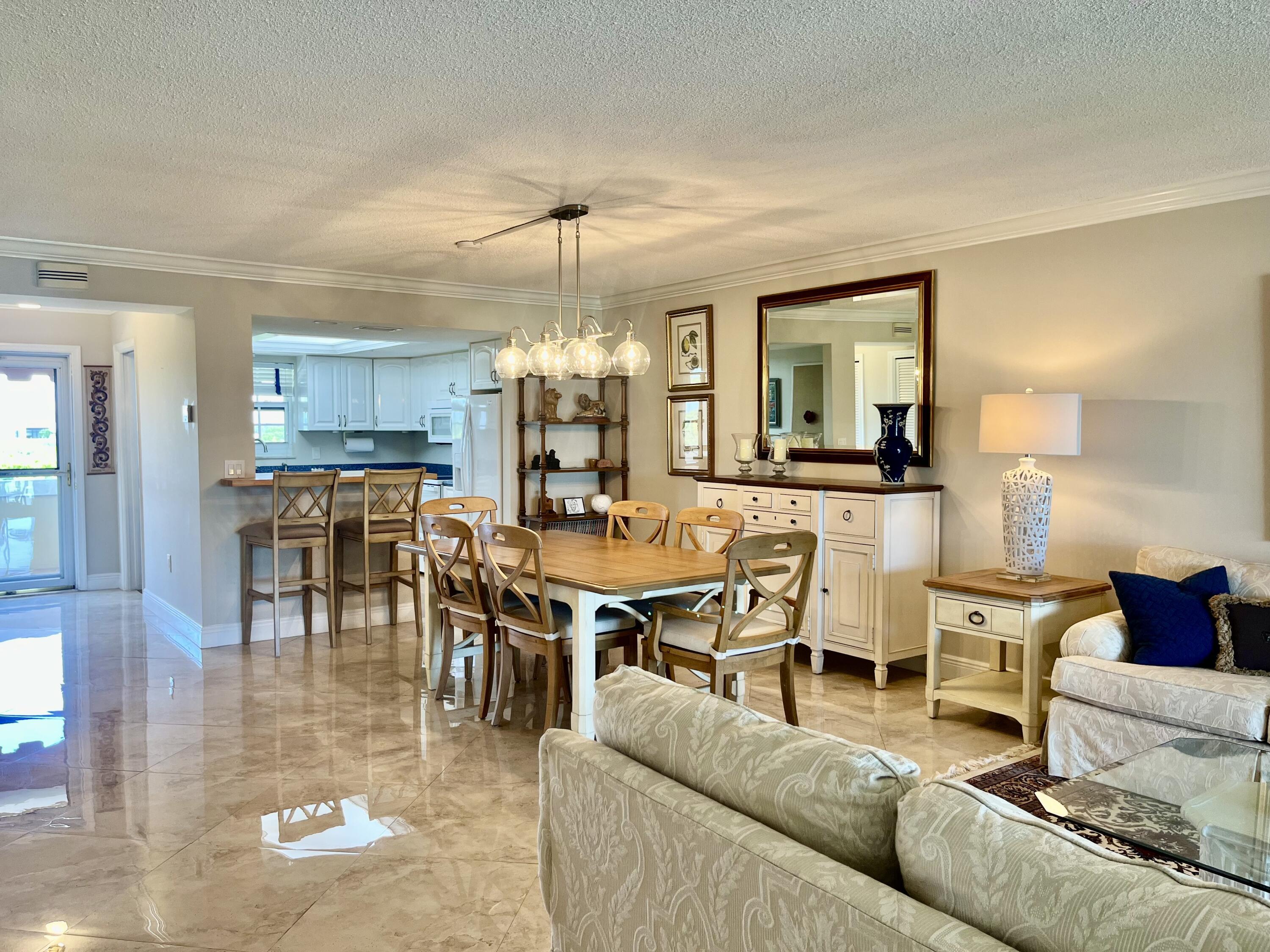 145 Atlantis Boulevard, Unit PH4 Atlantis, FL 33462 - Photo 9 of 27 a living room with lots of furniture and kitchen view