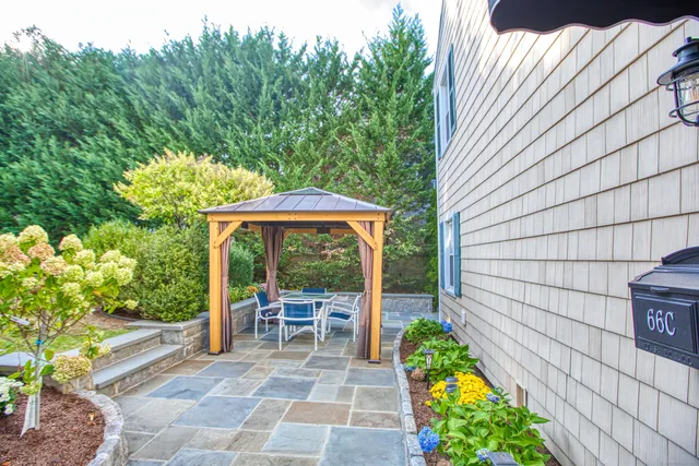 a view of a patio with table and chairs potted plants with wooden fence