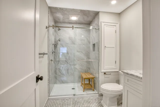 a bathroom with a sink a toilet and shower