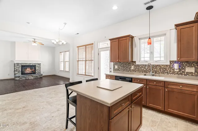 a kitchen with a sink a center island a wooden floor and a window