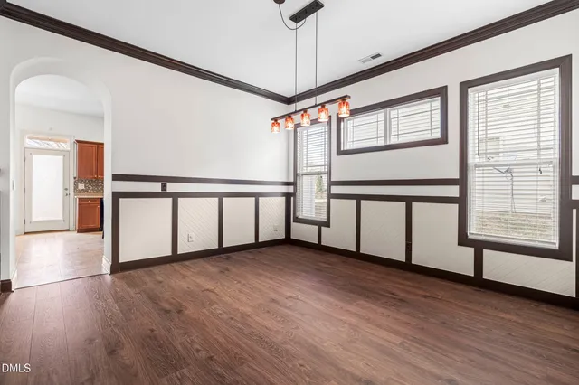 a view of a room with wooden floor and a floor to ceiling window
