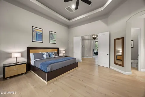 a spacious bedroom with a bed and a lamp