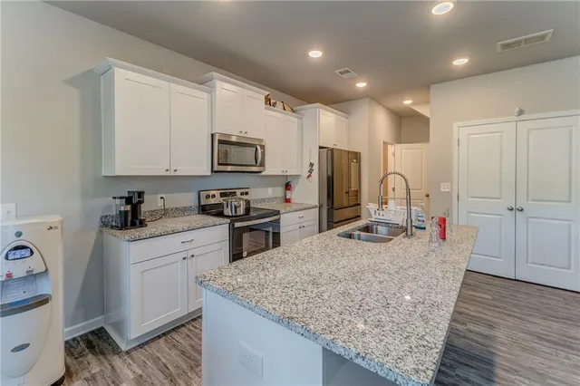 a kitchen with stainless steel appliances granite countertop a sink refrigerator and microwave