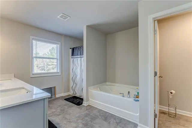 a bathroom with a bathtub and a window
