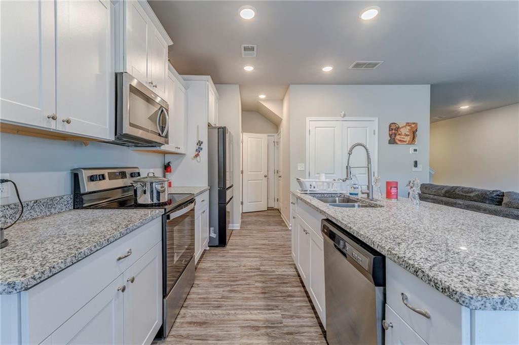 122 Old Mill Drive Calhoun, GA 30701 - Photo 10 of 25 a kitchen with stainless steel appliances granite countertop a sink stove and refrigerator