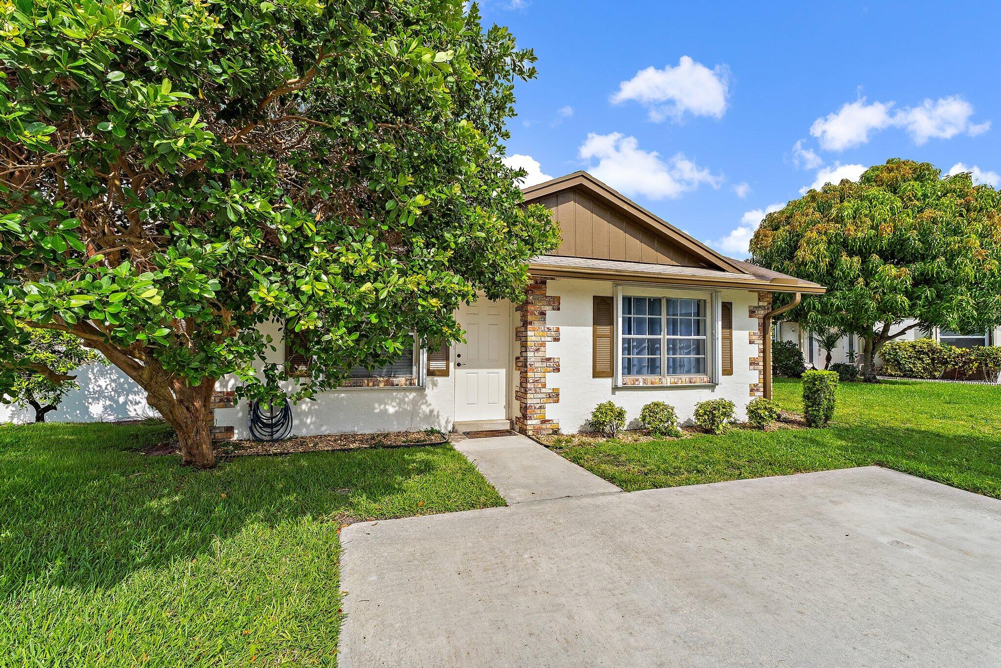109 Doe Trail Jupiter, FL 33458 - Photo 2 of 26 a front view of a house with a yard