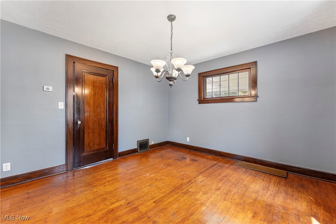 1623 Spangler Road Northeast Canton, OH 44714 - Photo 15 of 28 Empty room with hardwood / wood-style flooring and a chandelier